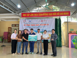 Đại diện nhà tài trợ trao biển tài trợ tượng trưng cho trẻ em bị ảnh hưởng lũ lụt tại xã Tam Quang dưới sự chứng kiến của Quỹ Bảo trợ trẻ em tỉnh